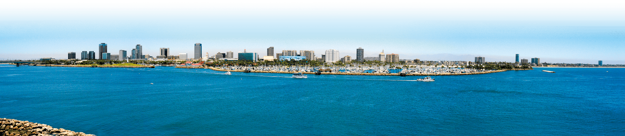 Boat marina in the Long Beach, California full of sailboats, yachts, and other motor operated boats. The panoramic view of the entire downtown area of Long Beach.